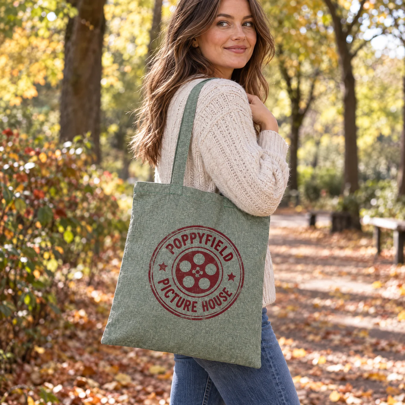 Green marl recycled cotton shopper printed with a cinema logo, carried on the shoulder in an autumn park