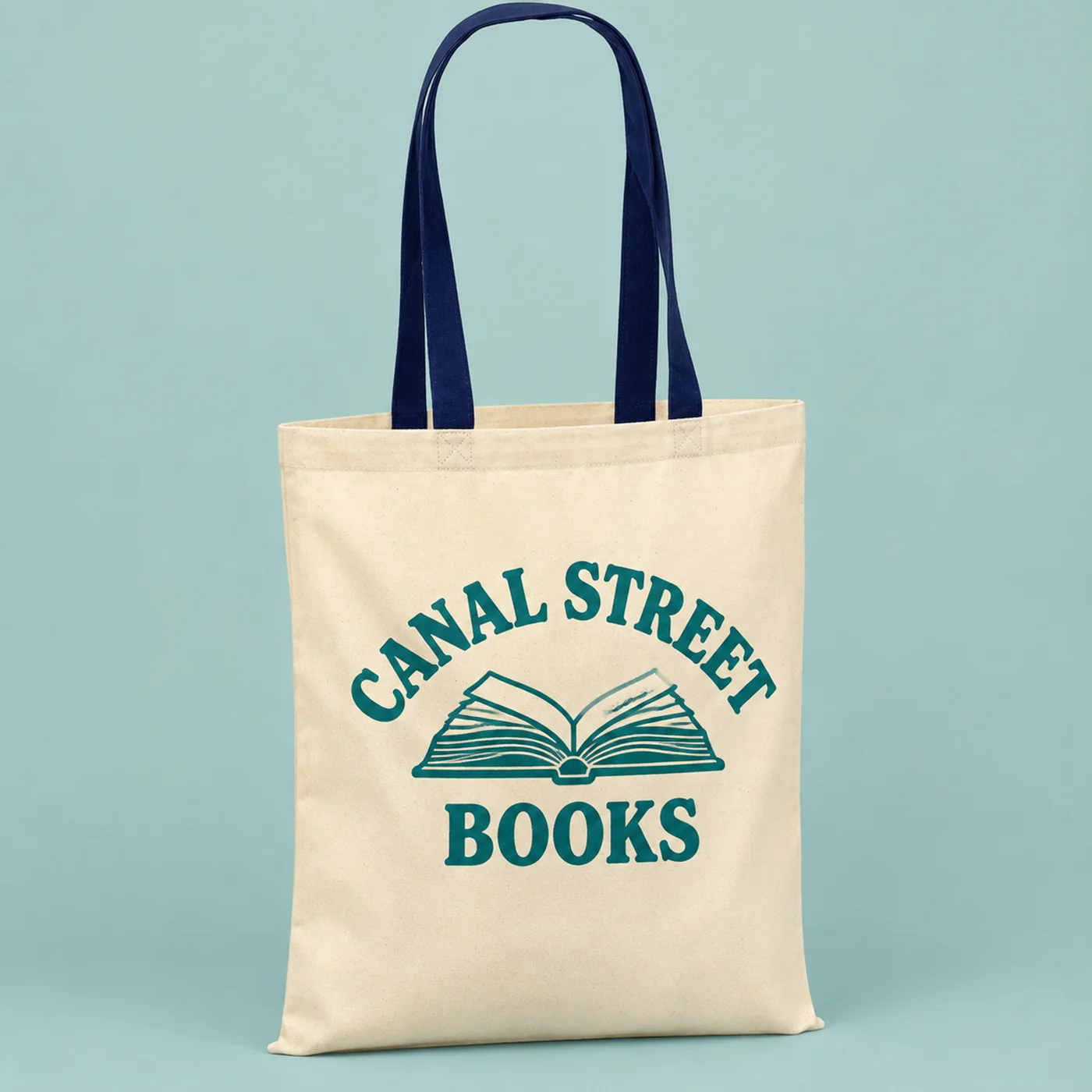 Natural cotton tote with navy handles, printed with a bookshop logo in teal